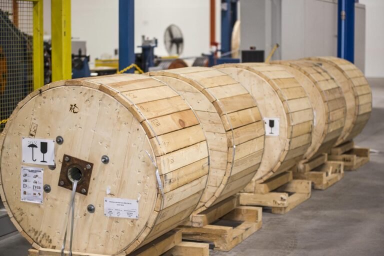 Large wooden reels of industrial cables in a factory.