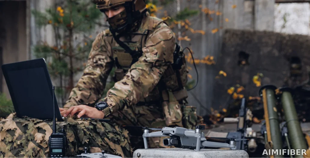 Terénní operátor s bezpilotním letadlem a taktickou rádiovou stanicí využívající robustní optické propojení – banner AIMIFIBER