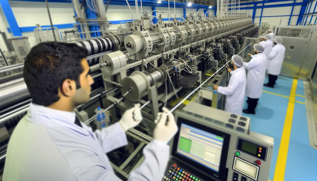 A fiber cable expert reviewing production metrics in a factory setting.